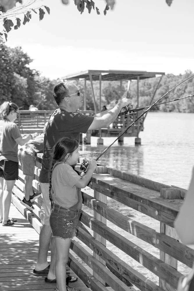PATIENT TEACHER: Jungmann helps 6-year-old Lydia Crafton learn how to fish. She is one of a record 13,000 students enrolled in summer school.